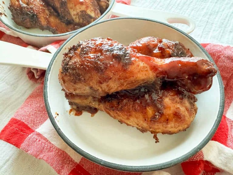 BBQ chicken legs in a white skillet.