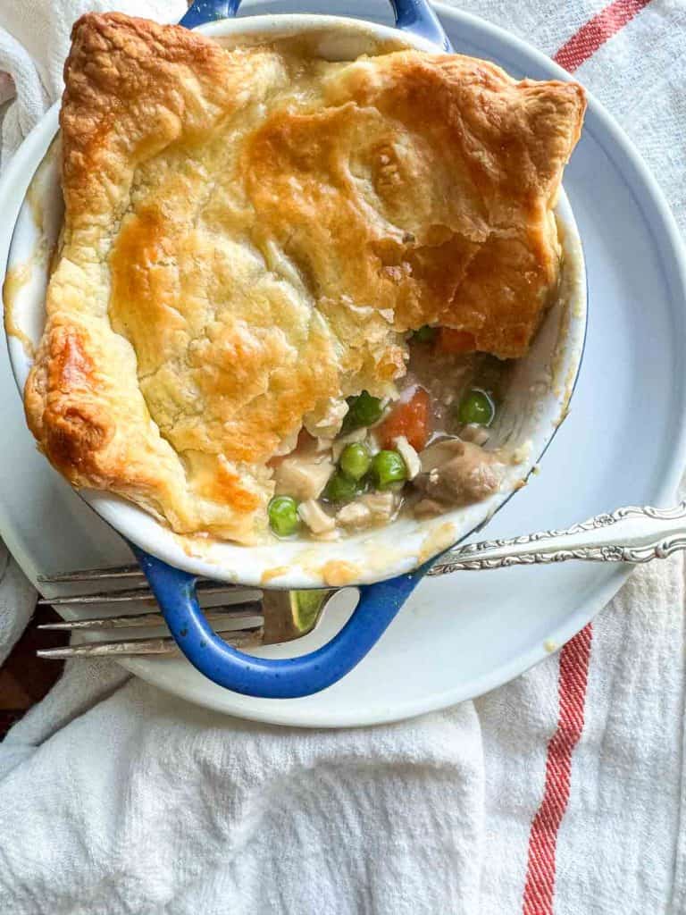 A pot pie with the crust broken open and a fork. 