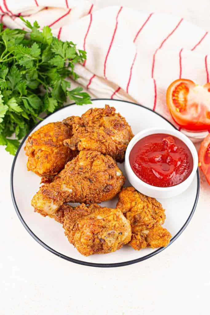 Fried Chicken on a plate with sauce for dipping.