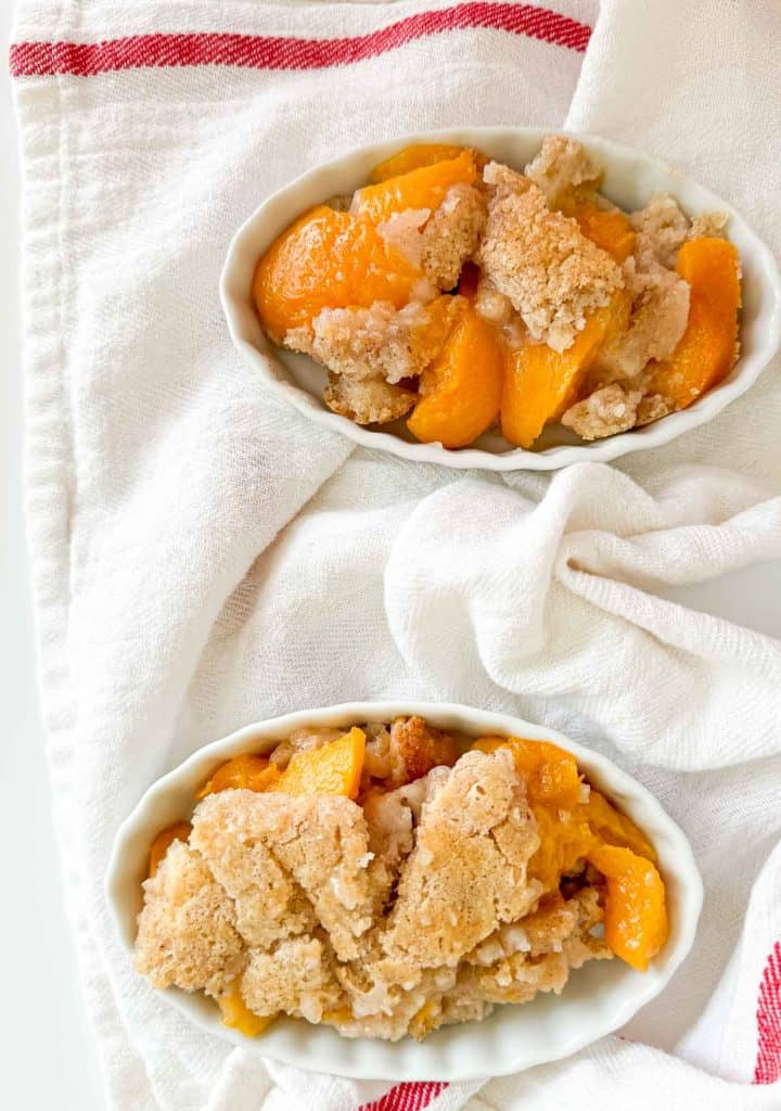 Two dishes of bisquick peach cobbler. 