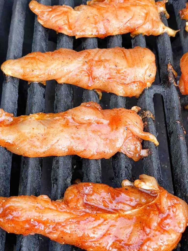 Grilling chicken cooking on the grate. 