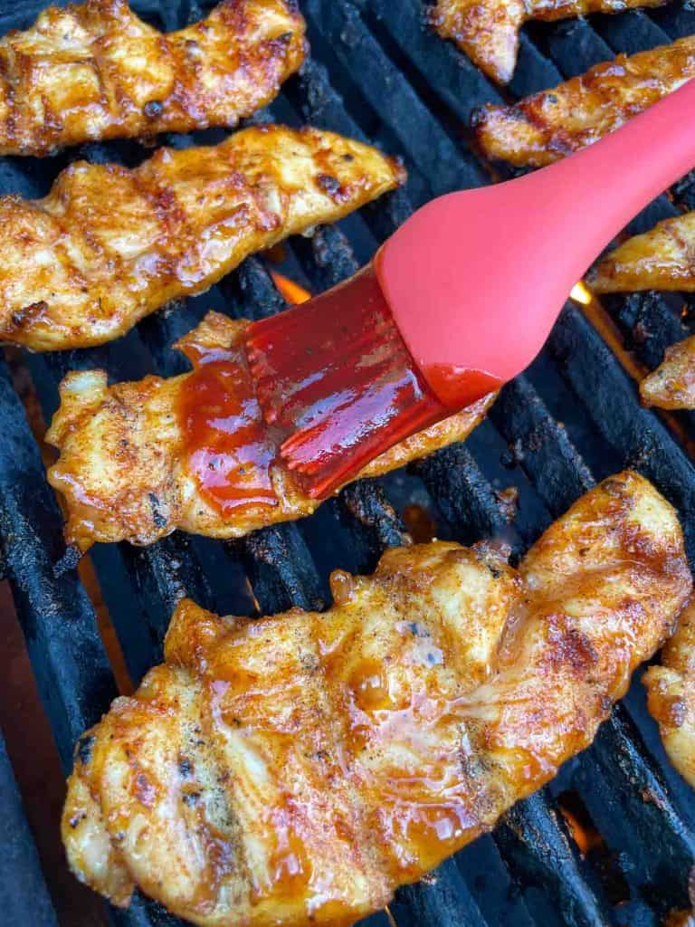 Brushing sauce on a piece of chicken.