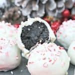 Peppermint Oreo truffles topped with crushed candy canes, with one truffle showing the Oreo filling.