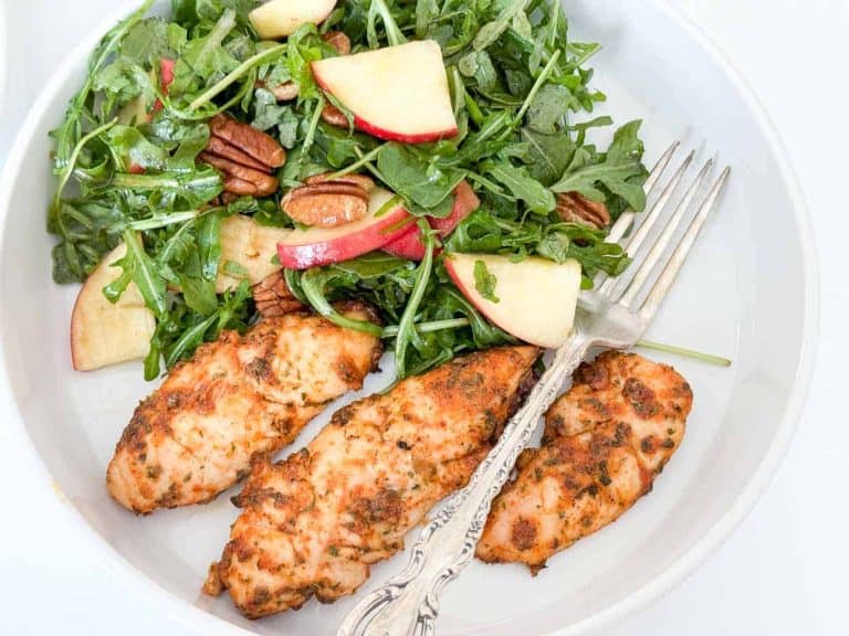 Baked ranch chicken tenders served alongside a fresh arugula salad.