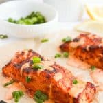 Close-up of Bang Bang Salmon with sauce and garnished with green onions.