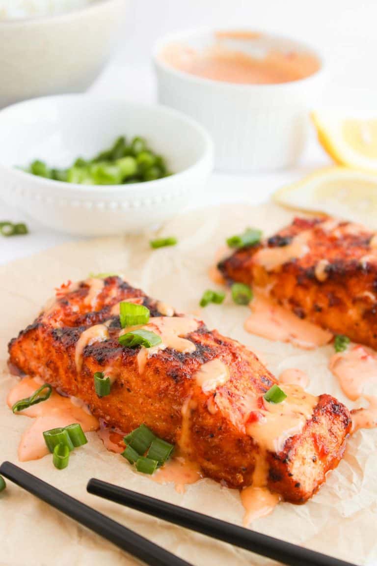 Close-up of Bang Bang Salmon with sauce and garnished with green onions.
