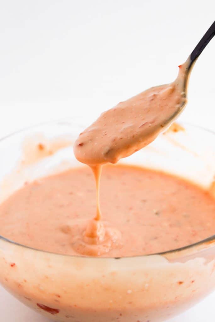 Mixed Bang Bang sauce dripping from a spoon.