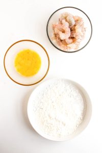 Raw shrimp, beaten egg, and cornstarch in separate bowls.