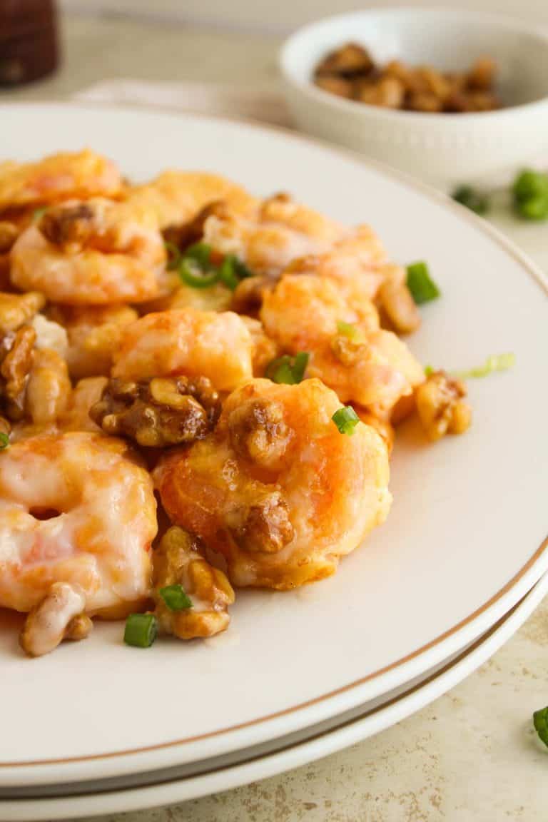 Close-up of honey walnut shrimp on a white plate.