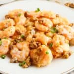 Side view of honey walnut shrimp on a white plate.