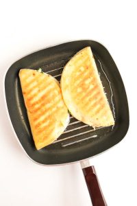 Golden-brown, crispy quesadillas in the pan.