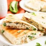 Quesadillas on a plate with a second plate in the background.