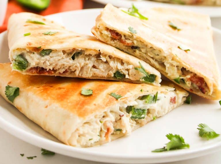 Extreme close-up of quesadillas with golden tortillas and gooey filling.