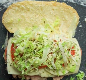 Shredded lettuce and seasonings topping the tomato and cheese layers.