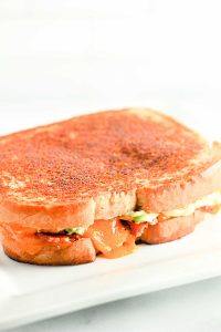 Grilled cheese is golden brown with melted cheese oozing out.