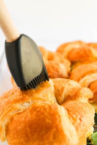 Brushing croissants with butter or egg wash.