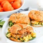 Close view of croissant breakfast sandwichs with oranges.