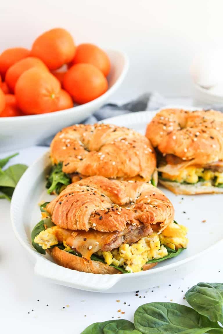 Close view of croissant breakfast sandwichs with oranges.
