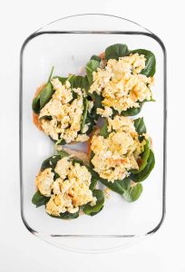 Eggs layered on spinach and croissants.