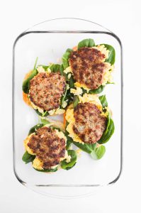 Sausage patties added to sandwich layers.