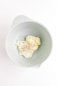 Cream cheese, mayonnaise, salt, and pepper in a bowl.
