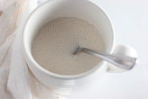 White mug with stirred white mug cake batter.