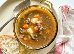 Overhead view of stew in a bowl with bread and spoon on the side.