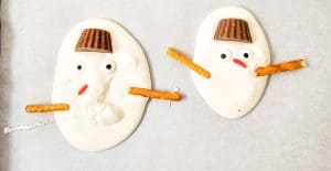 Pretzel sticks used as snowman arms.