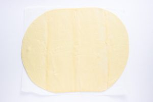 Rolled out pastry dough on parchment paper.