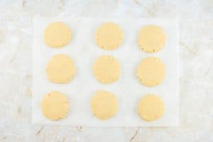 Flattened cookie dough rounds on parchment paper.