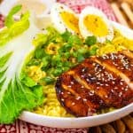 Close-up of chicken ramen showing sliced chicken, noodles, and soft-boiled eggs.