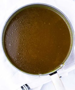 Ramen broth simmering in a saucepan.