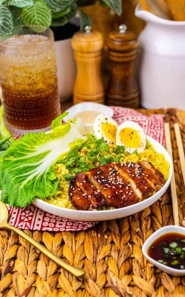 Chicken ramen bowl with noodles, bok choy, egg, and sesame chicken.