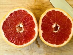 Halved grapefruit on a cutting board for Broiled Grapefruit.