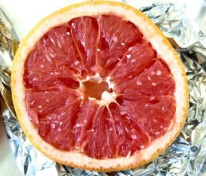 Close-up of grapefruit half on foil sprinkled with salt for Broiled Grapefruit.