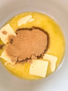 Brown sugar added on top of melted butter in a saucepan.