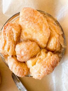 Close-up of baked monkey bread in a glass ramekin with a golden, sugar-coated top.