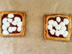 Puff pastry pizzas with melted mozzarella pearls.
