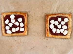 Baked puff pastry pizzas topped with mozzarella pearls before returning to the oven.
