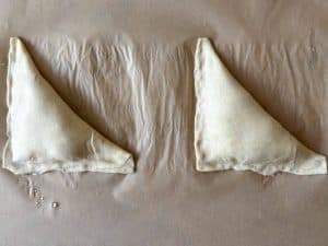 Two folded triangular turnovers sealed along the edges on parchment paper.